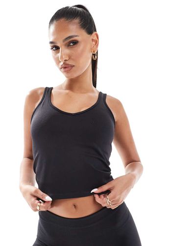 Canotta sportiva senza cuciture nera con scollo a V e reggiseno interno - ASOS - Modalova