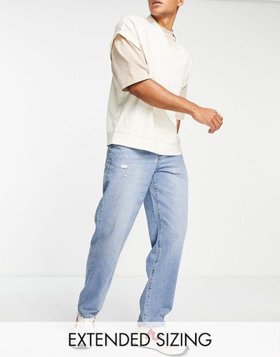 Jeans ampi lavaggio medio con abrasioni - ASOS DESIGN - Modalova