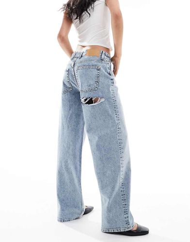 Jeans boyfriend ampi a vita medio alta medio con strappo sul retro - ASOS DESIGN - Modalova