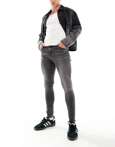 Jeans in power stretch nero slavato effetto spray - ASOS DESIGN - Modalova