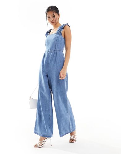 Tuta jumpsuit in morbido denim medio con spalline a volant - ASOS DESIGN - Modalova