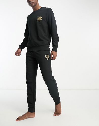 Bodywear - Completo da casa nero con felpa e joggers con logo dorato - Emporio Armani - Modalova