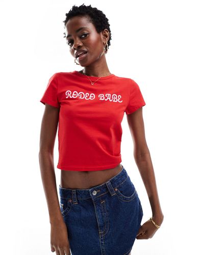 T-shirt mini rossa con stampa "Rodeo Babe" sul davanti - Monki - Modalova