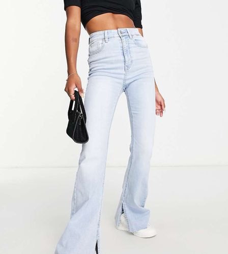 Petite - Jeans a zampa elasticizzati azzurri con spacco - Stradivarius - Modalova