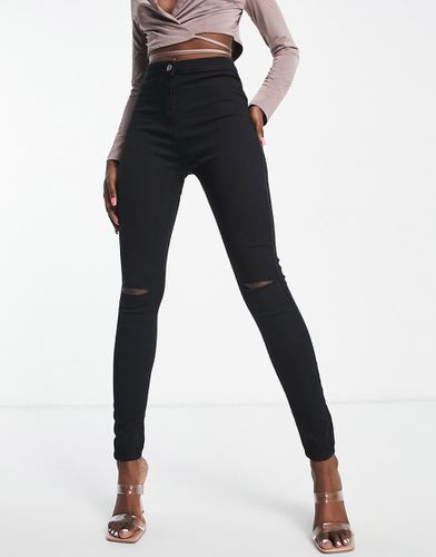 Jeggings di jeans elasticizzati neri con strappo sul ginocchio - Rebellious Fashion - Modalova