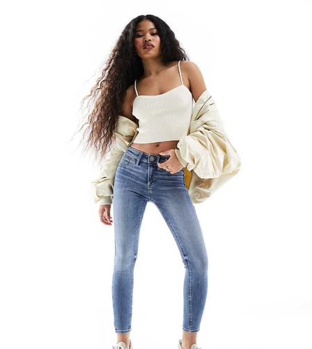 Jeans skinny a vita medio alta lavaggio medio - River Island Petite - Modalova