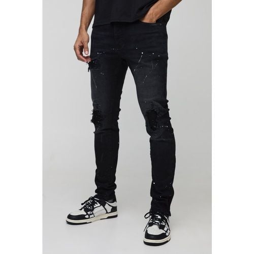 Jeans Skinny Fit stile Biker con schizzi di colore, strappi & rattoppi e zip sul fondo - boohoo - Modalova