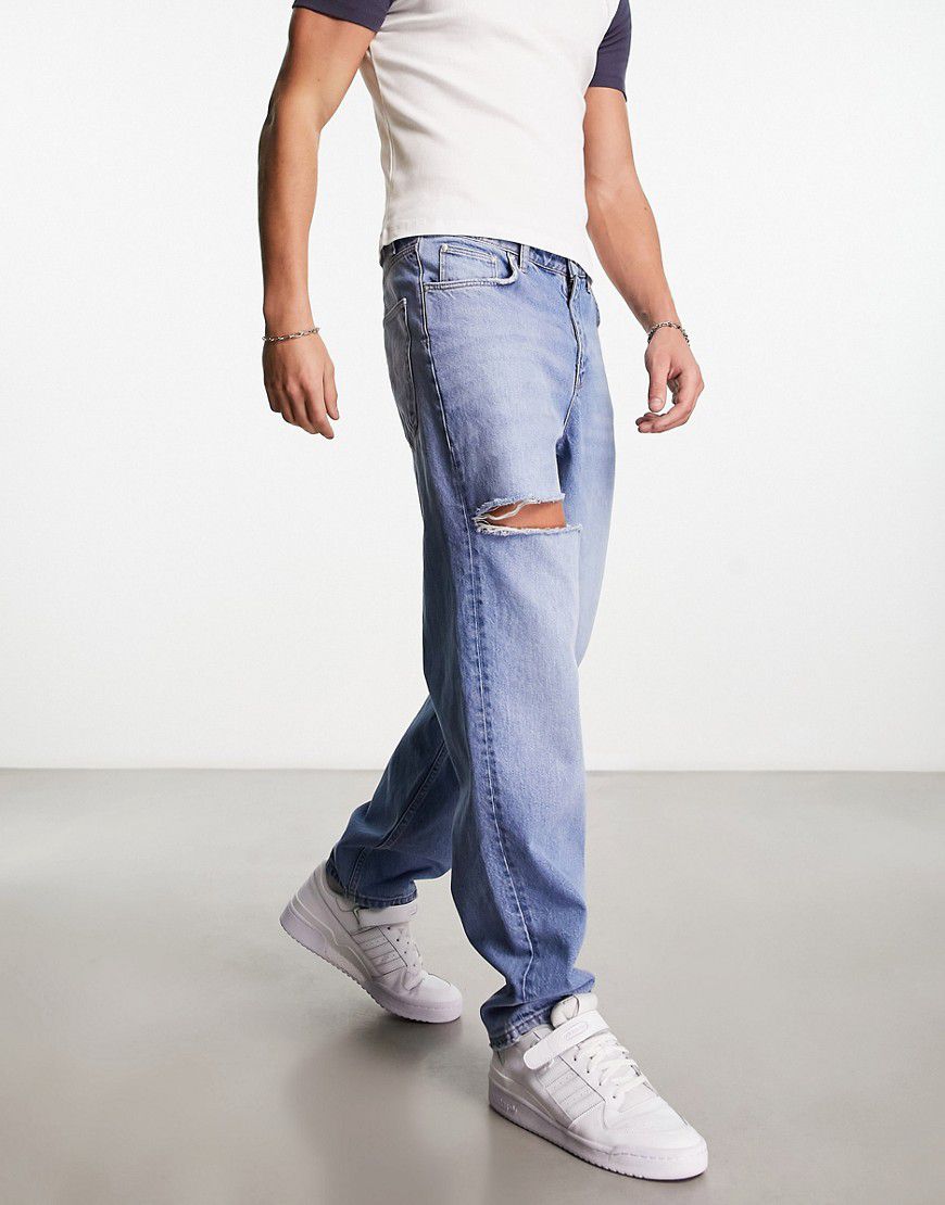 Jeans larghi con strappi lavaggio medio - ASOS DESIGN - Modalova